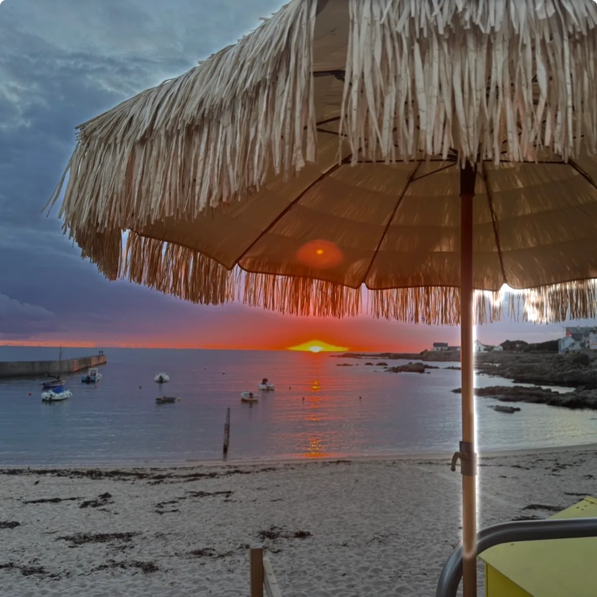 Coucher de soleil sous le parasol en paille